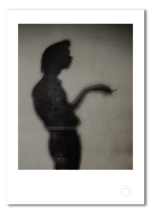 Colour portrait of Nick Cave’s shadow by Gavin Evans, 1989. Cigarette in hand, unmistakable silhouette. A3 giclée print with white border, Nick Cave Collection.