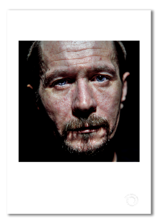 Colour close-up portrait of Gary Oldman by Gavin Evans, 1998. Intense gaze from black background. A3 giclée print with white border, Icons Collection.