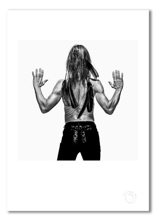 Black and white rear studio portrait of Iggy Pop by Gavin Evans, 1996. Bare back with compressed skin folds and feathers. A3 giclée print with white border, Iggy Pop Collection.