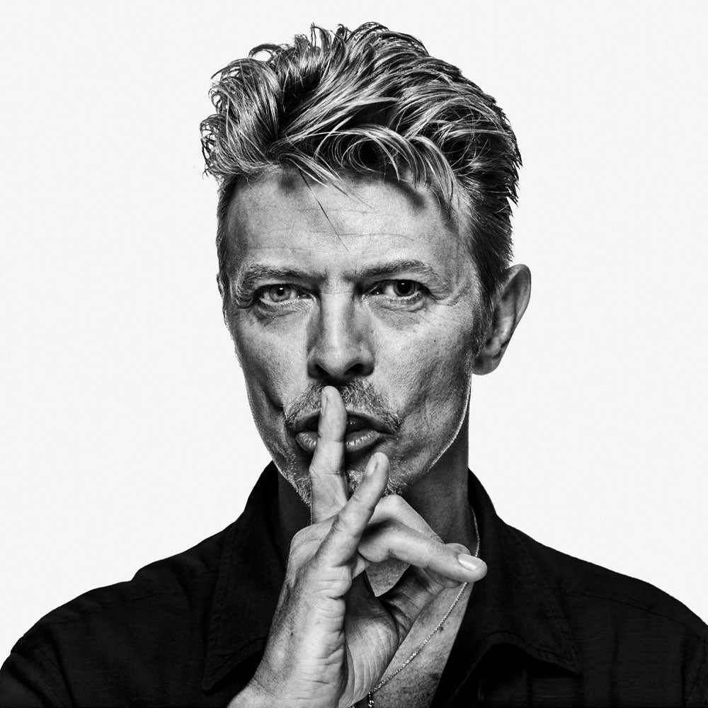 Full-frame black and white “Shh” image of David Bowie by Gavin Evans. Finger to lips, globally recognised portrait, David Bowie Collection.