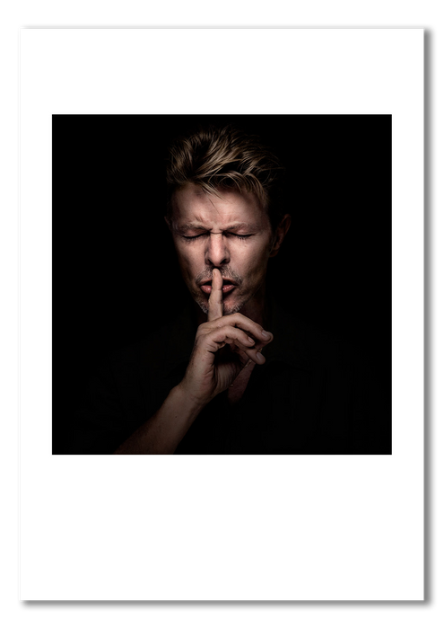 Colour portrait of David Bowie by Gavin Evans, 1995. Eyes closed in intense shushing pose. A3 giclée print with white border, Bowie Collection.