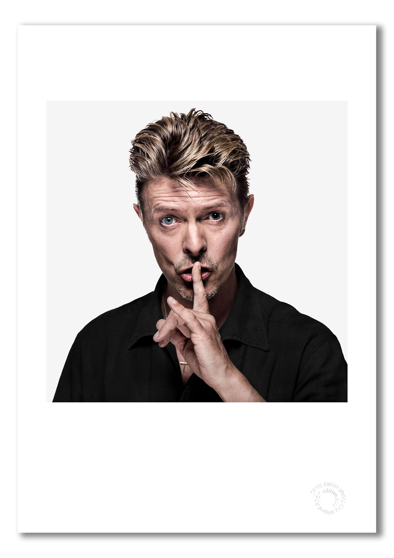 Colour portrait of David Bowie by Gavin Evans, 1995. Shushing pose against white background. A3 giclée print with white border, Bowie Collection.