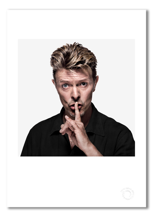Colour portrait of David Bowie by Gavin Evans, 1995. Shushing pose against white background. A3 giclée print with white border, Bowie Collection.