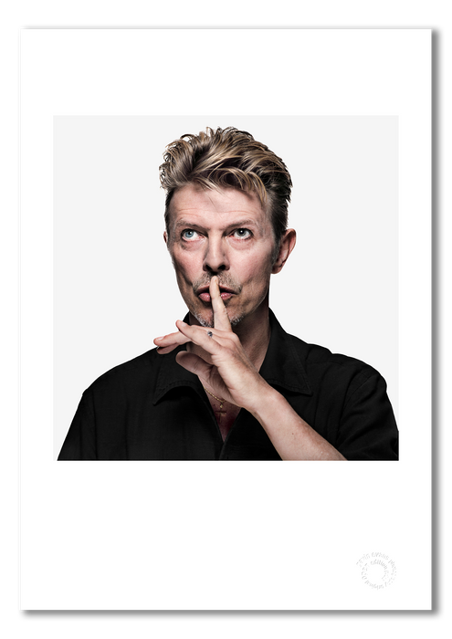 Colour portrait of David Bowie by Gavin Evans, 1995. Shushing pose with off-camera gaze. A3 giclée print with white border, Bowie Collection.