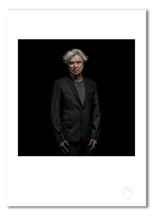 A3 open edition fine art print of David Byrne with a white border, printed on semi-matt archival cotton paper. This 2018 colour studio portrait was taken in Berlin by Gavin Evans and is embossed for authenticity.