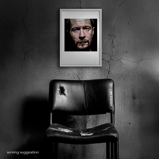 Framed colour portrait of Gary Oldman by Gavin Evans, 1998. Intense black background image displayed in a distressed room, Icons Collection.