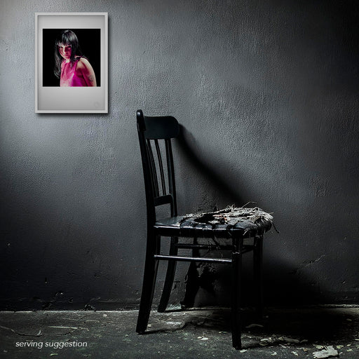 Framed display of the Björk A3 fine art print in a weathered room setting. The colour image’s delicate pose and deep black backdrop provide a gentle, introspective contrast to the raw, aged environment.