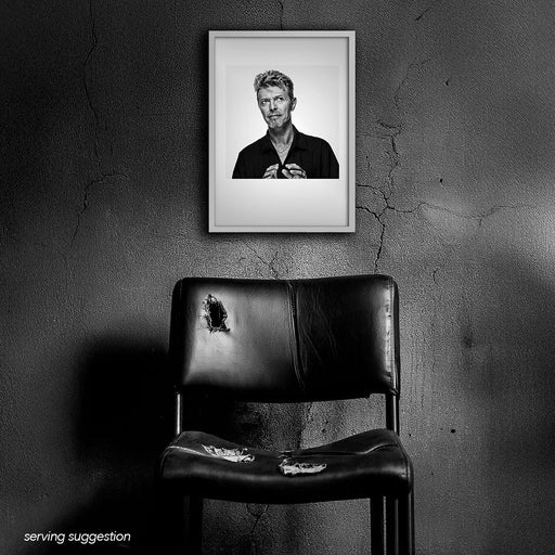 Framed black and white portrait of David Bowie by Gavin Evans. Caught looking away, displayed in run-down interior, Bowie Collection.