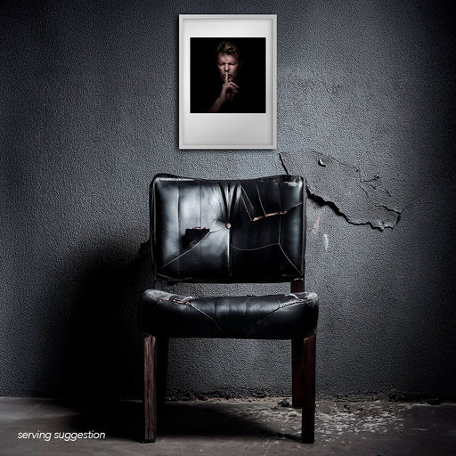 Framed colour portrait of David Bowie by Gavin Evans. Eyes shut, shushing with intensity. Displayed in dilapidated monochrome interior, Bowie Collection.