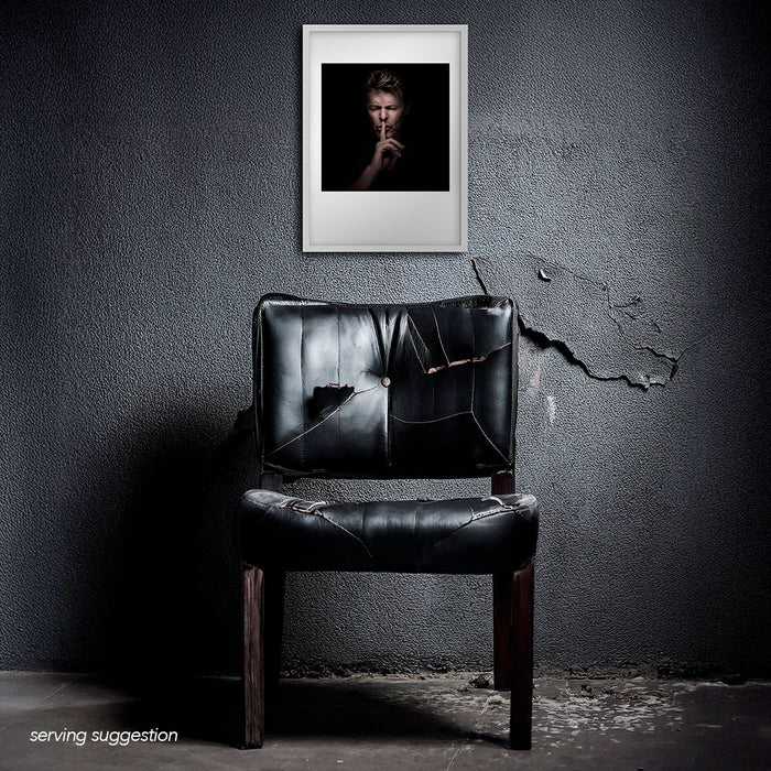 Framed colour portrait of David Bowie by Gavin Evans. Eyes shut, shushing with intensity. Displayed in dilapidated monochrome interior, Bowie Collection.