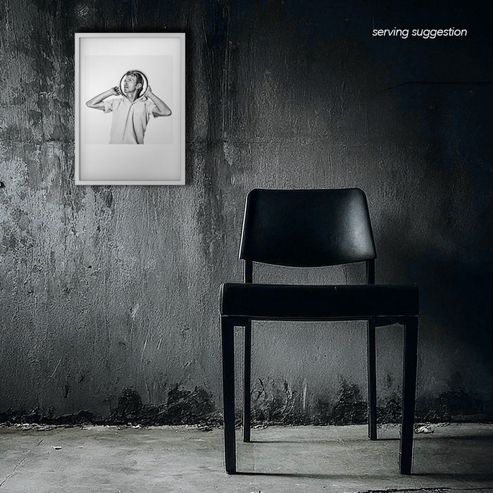 Framed black and white portrait of David Bowie posing with tray halo. Parody image displayed in dilapidated monochrome room, Bowie Collection.