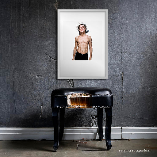 Framed portrait of Iggy Pop by Gavin Evans, 1996. Chanting or singing, adorned with black feathers, displayed in raw setting, Iggy Pop Collection.