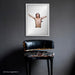 Framed Iggy Pop portrait by Gavin Evans, 1996. Bare torso, cruciform stance with feathers, hung against a monochrome wall, Iggy Pop Collection.