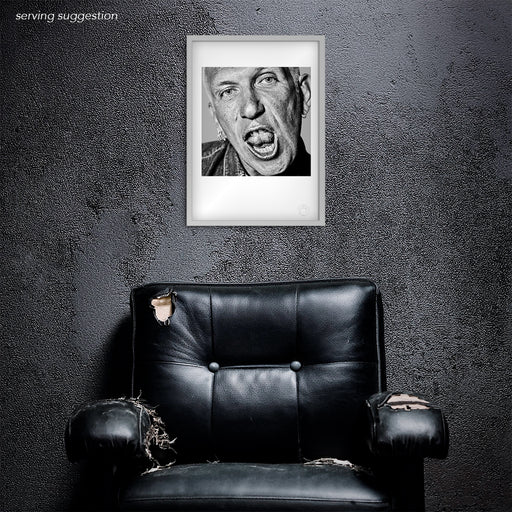 Framed view of the Jean Paul Gaultier A3 fine art print displayed in a weathered interior. The black and white studio image exudes timeless cool and creative intensity — perfectly matched to its iconoclastic subject.