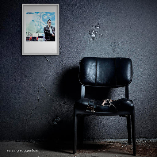 Framed Joe Strummer portrait by Gavin Evans, 1988. Iconic Clash image displayed in distressed interior, Icons Collection.