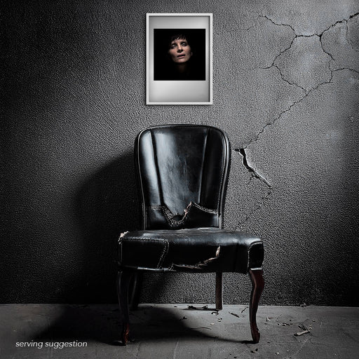 The Juliette Binoche A3 portrait framed and displayed in a textured, aged interior. The minimal, dark composition stands in elegant contrast to the raw surroundings, enhancing the theatrical mood of the 2015 Paris session.
