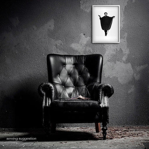 A framed view of the Malcolm McLaren A3 fine art print in a distressed, textured room. The stark black and white image stands in provocative contrast to the raw surroundings, reflecting McLaren’s punk ethos.