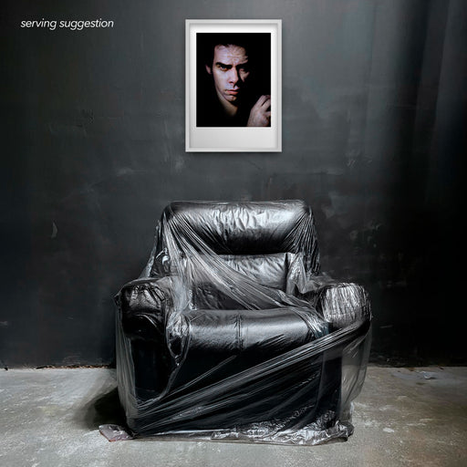 Framed colour portrait of Nick Cave by Gavin Evans. Full-frame image against black. Displayed in monochrome room, Nick Cave Collection.