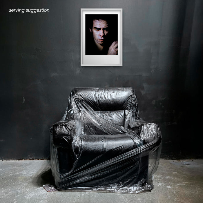 Framed colour portrait of Nick Cave by Gavin Evans. Full-frame image against black. Displayed in monochrome room, Nick Cave Collection.