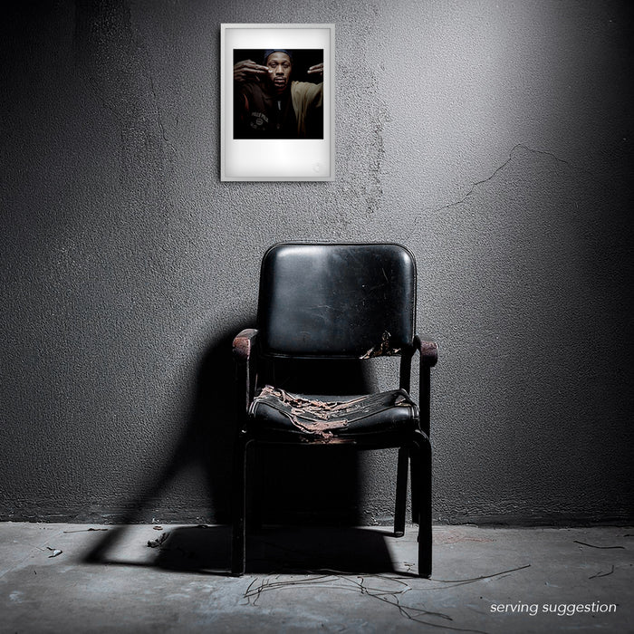 Framed version of the RZA #2 A3 fine art print displayed in a weathered interior. The portrait’s mood and minimalism contrast strikingly with the textured backdrop, enhancing its meditative power.