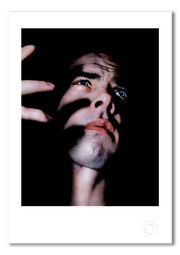 Nick Cave #4, semi-profile, finger shadows on face, colour, black background, Bayswater London 1989, by Gavin Evans — fine art photography print