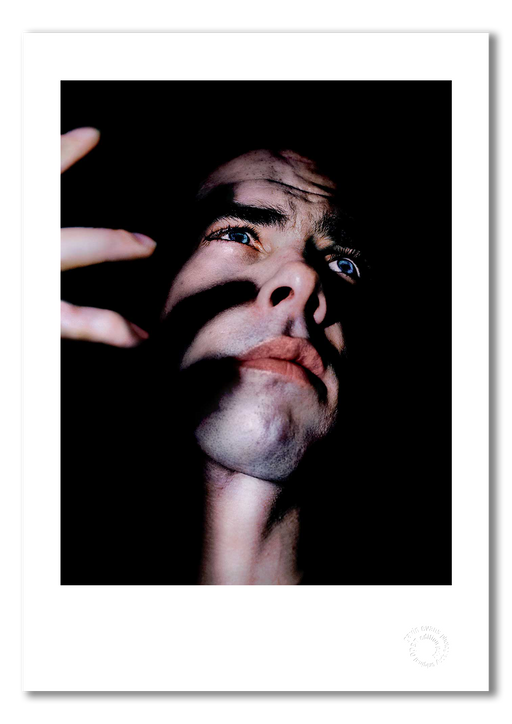 Nick Cave #4, semi-profile, finger shadows on face, colour, black background, Bayswater London 1989, by Gavin Evans — fine art photography print