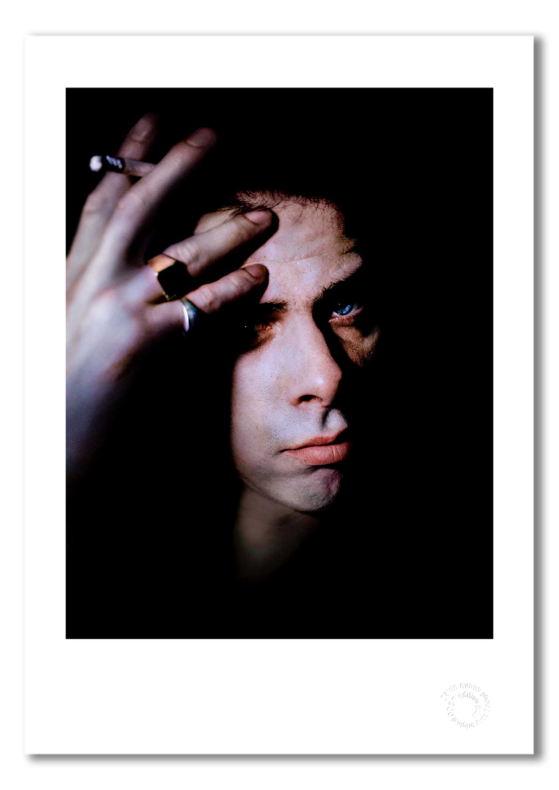 Nick Cave #5, direct gaze, lit cigarette, colour, black background, Bayswater London 1989, by Gavin Evans — fine art photography print