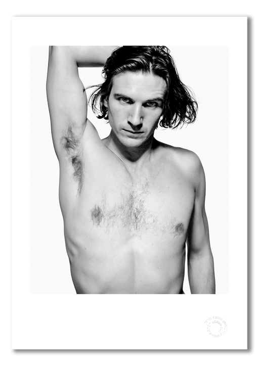 A3 open edition giclée print of Ralph Fiennes, waist-up and shirtless, printed with a white border on semi-matt archival cotton paper. This 1991 portrait by Gavin Evans presents the actor in sharp black and white contrast. Embossed for authenticity.