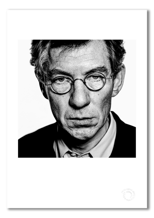 A3 open edition giclée print of Sir Ian McKellen featuring a white border, printed on semi-matt archival cotton paper. Captured in 1996, this close-up black and white portrait by Gavin Evans is embossed for authenticity and part of the Icons Collection.